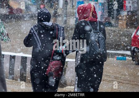Srinagar, Indien. 12. Januar 2023. Studenten gehen durch eine Straße inmitten von anhaltendem starkem Schneefall am Stadtrand von Srinagar. Mindestens zwei Arbeiter wurden am Donnerstag getötet, nachdem eine Lawine in die Höhenlage in der Sonamarg im Zentrum Kaschmirs geriet. Die meisten Teile Kaschmirs erlitten einen frischen Schneefall, der zur Schließung der Hauptstraße der Hauptstadt Kaschmir führte, die die umstrittene Region mit dem Rest Indiens verbindet. Die Flughafenbehörden haben den Flugbetrieb bis auf weiteres eingestellt, da es ständig Schneefall und schlechte Sicht gab. Kredit: SOPA Images Limited/Alamy Live News Stockfoto