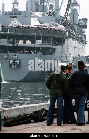 Leinenarbeiter stehen bereit, während ein großer Hafenschlepper den Zerstörer USS YELLOWSTONE (AD-41) neben den Pier bringt. Der YELLOWSTONE kehrt nach Norfolk zurück, nachdem er zur Unterstützung der Operation Desert Shield und der Operation Desert Storm in die Region des Persischen Golfs entsandt wurde. Ein Angriffsgeschwader 35 (VA-35) A-6E Intruder-Flugzeug sitzt auf dem HUBSCHRAUBERDECK des YELLOWSTONE. Betreff Operation/Serie: WÜSTENSCHILD WÜSTENSTURM Stützpunkt: Marineflugstation, Norfolk Bundesstaat: Virginia (VA) Land: Vereinigte Staaten von Amerika (USA) Stockfoto