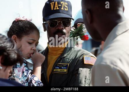 LT. CMDR. Greg Sawyer, ein bombardier-Navigator mit Angriffsschwadron 75 (VA-75), wird mit seiner Familie auf der Fluglinie wieder vereint. VA-75 ist nach dem Einsatz in der Region Persischer Golf an Bord des Flugzeugträgers USS JOHN F. KENNEDY (CV-67) für Operation Desert Shield und Operation Desert Storm nach Oceana zurückgekehrt. Betreff Operation/Serie: WÜSTENSCHILD WÜSTENSTURM Stützpunkt: Marineflugstation, Oceana Bundesstaat: Virginia (VA) Land: Vereinigte Staaten von Amerika (USA) Stockfoto