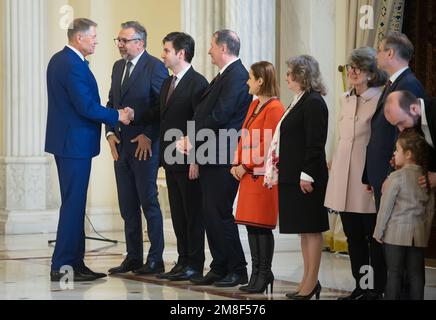 Bukarest, Rumänien - 13. Januar 2023: Der rumänische Präsident Klaus Iohannis schüttelt Liviu Sebastian Jicman bei der Dekoration des Nationalkulturtages die Hand Stockfoto