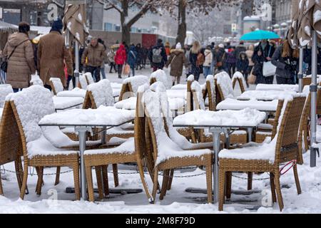 Schneebedeckte Tische und Stühle, Straßencafé im Winter, viele Leute, geschäftige Einkaufsstraße, Fußgängerzone, Kaufingerstraße, Neuhauser Straße, Alt Stockfoto