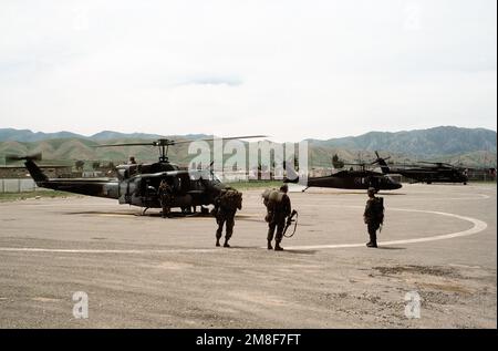 Ein UH-1N Iroquois, UH-60 Black Hawk und CH-53E Super Hallion Hubschrauber stehen in der Schlange an einem Hubschrauberlandeplatz in der Nähe eines kurdischen Flüchtlingslagers. Die Helikopter werden während der Operation Provide Comfort eingesetzt, einer alliierten Anstrengung, um den Flüchtlingen zu helfen, die vor den Truppen von Saddam Hussein im Nordirak geflohen sind. Betreff Betrieb/Serie: KOMFORT bereitstellen Basis: Zakhu Land: Irak (IRQ) Stockfoto