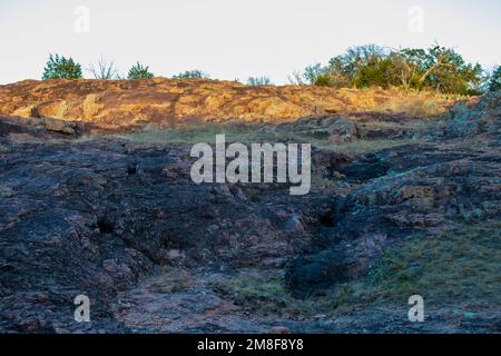 Die Kanonenwand im Inks Lake State Park Burnet Texas beleuchtet den Granitsteinvorsprung mit Sonnenlicht Stockfoto