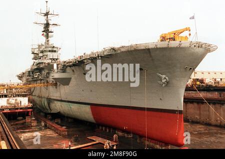 Das amphibische Sturmschiff USS TRIPOLI (LPH-10) befindet sich im Trockendock nach Reparatur eines großen Lochs 10 Fuß unter seiner Wasserlinie. Vier Seeleute wurden verletzt und das Schiff wurde schwer beschädigt, als am 18. Februar in der Nähe der TRIPOLIS eine irakische Mine explodierte, als Hubschrauber des Schiffes während der Operation Desert Storm Minenräumungen im Persischen Golf durchführten. Betreff Operation/Serie: WÜSTENSTURMBASIS: Bahrain Land: Bahrain (BHR) Stockfoto