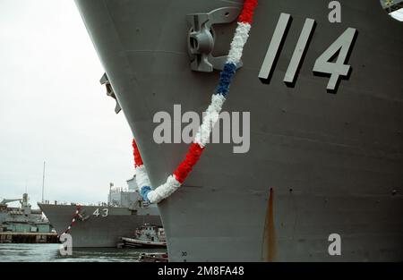 Eine Girlande schmückt den Bug des Amphibienschiffs USS DURHAM (LKA-114), während das Schiff nach seiner Rückkehr vom Einsatz im Persischen Golf während der Operation Desert Storm im Hafen liegt. Im Hintergrund manövriert der große Hafenschlepper CANONCHET (YTB-823) das Dock-Landungsschiff USS FORT MCHENRY (LSD-43), das ebenfalls gerade vom Golf zurückgekehrt ist, in Richtung eines Piers. Betreff Operation/Serie: WÜSTENSTURMBASIS: San Francisco Bay Bundesstaat: Kalifornien (CA) Land: Vereinigte Staaten von Amerika (USA) Stockfoto