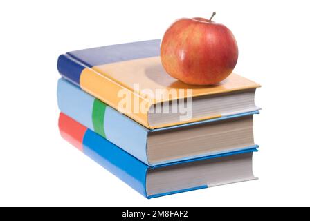 Ein Stapel Bücher mit einem Apfel auf Weiß Stockfoto