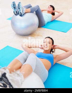 Setzt sich für makellose bauchmuskeln ein. Eine Frau, die sich während eines Pilates-Kurses aufsetzt. Stockfoto