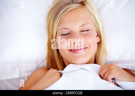 Ich habe eine schöne Schlummerfunktion. Junge Frau, die bequem im Bett lag, mit geschlossenen Augen. Stockfoto