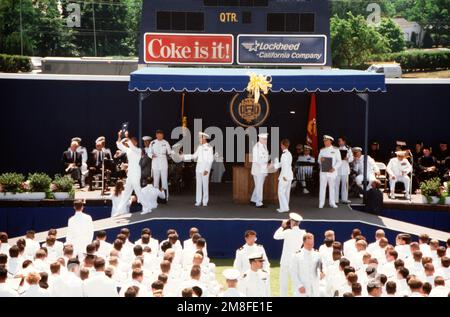 EIN Mitglied der Marineakademie der Klasse 1991 wird von GEN H. Norman Schwarzkopf, Center, Oberbefehlshaber der USA, beglückwünscht Zentralkommando, bevor er sein Diplom während der Abschlussfeier der Akademie und der Inbetriebnahmezeremonie erhielt. Fast 20.000 Gäste nahmen an der Zeremonie im Navy-Marine Corps Stadium Teil, bei der 937 Fähnrich-Männer ihren Abschluss machten. Basis: US Naval Academy, Annapolis Bundesstaat: Maryland (MD) Land: Vereinigte Staaten von Amerika (USA) Stockfoto