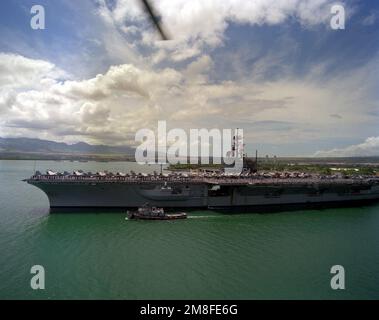 Seeleute bewachen die Schienen an Bord des Flugzeugträgers USS RANGER (CV-61), während der große Hafenschlepper WAXAHATCHIE (YTB-814) das Schiff in Vorbereitung auf die Unterstützung beim Andocken begleitet. Der RANGER hält in Pearl Harbor auf dem Weg zu seinem Heimathafen, nachdem er während der Operation Desert Storm vom Persischen Golf zurückgekehrt ist. Betrifft Operation/Serie: WÜSTENSTURMBASIS: Pearl Harbor Bundesstaat: Hawaii (HI) Land: Vereinigte Staaten von Amerika (USA) Stockfoto