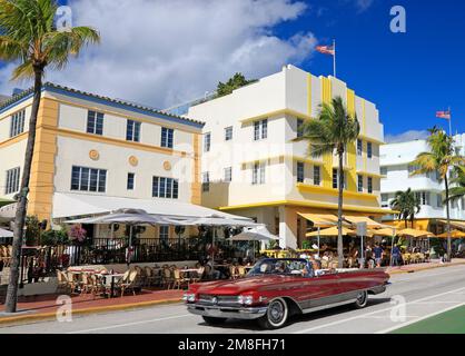 Morgenstimmung am Ocean Drive, Touristen, die ein klassisches rotes amerikanisches Cabrio im Art déco Historic District, Miami Beach, benutzen Stockfoto