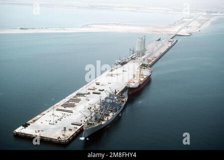 Der vom Sealift-Kommando gecharterte Frachter CAPE BON (T-AK-5059) steht am Pierside mit offenen Frachträumen. Das Schiff wird nach Operation Desert Storm Ausrüstung und Kampfmittel für die Umverteilung in die Vereinigten Staaten übernehmen. Ein Handelsschiff liegt hinter CAPE BON. Betreff Operation/Serie: WÜSTENSTURM Land: Saudi-Arabien (Sau) Stockfoto