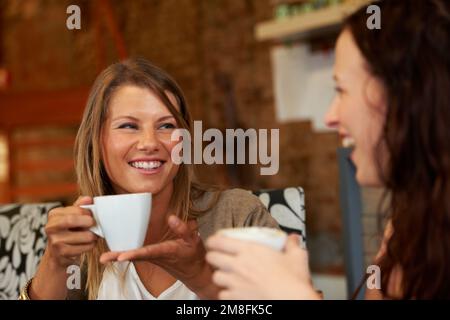 Was du nicht sagst. Zwei Freundinnen, die sich beim Kaffee über alte Zeiten unterhalten. Stockfoto