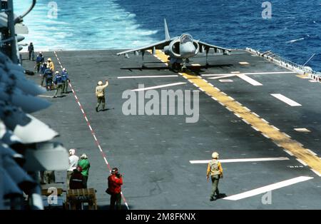 Ein Besatzungsmitglied signalisiert dem Piloten eines AV-8B-Harrier-Flugzeugs, das gerade an Bord des Amphibienschiffs USS WASP (LHD-1) gelandet ist. Das Flugzeug ist an das Marine Medium Helicopter Squadron 162 (HMM-162) angeschlossen, das beim ersten Einsatz des Schiffes an Bord des WASP geht. Land: Mittelmeer (MED) Stockfoto