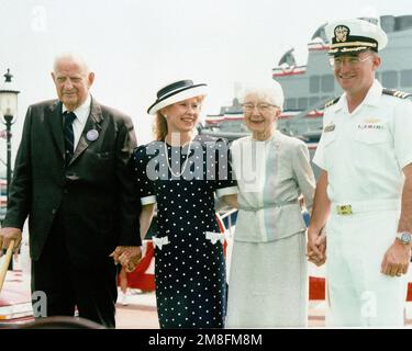 Vor der Inbetriebnahmezeremonie für den Raketenzerstörer USS ARLEIGH BURKE (DDG-51) pensionierte ADM Arleigh Burke, Left, eine unbekannte Frau, Roberta Burke, die zweite von rechts, UND COMMANDER John G. Morgan Jr., der kommandierende Offizier des Schiffes, stellt sich zusammen für ein Foto. Basis: Norfolk Bundesstaat: Virginia (VA) Land: Vereinigte Staaten von Amerika (USA) Stockfoto