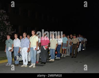 Rekruten stellen sich auf gelben Fußabdrücken auf, die auf der Straße gemalt wurden, nachdem sie aus dem Bus gestiegen sind, der sie zum Rekrutierungslager gebracht hat. Basis: USMC Recruit Depot, Parris Island Bundesstaat: South Carolina (SC) Land: Vereinigte Staaten von Amerika (USA) Stockfoto