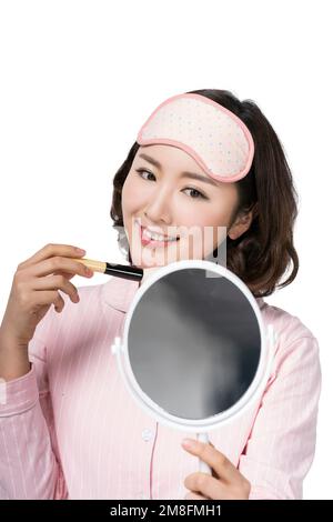 Er trug einen Pyjama im Make-up einer jungen Frau Stockfoto