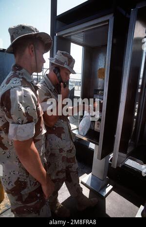 Lance CPL. Daniel Wirth telefoniert als Lance CPL. John Winters folgt ihrer Ankunft im Hafen. Die Marines, beide Mitglieder von Co L, 3. Mrd., 1. Marine Div., sind in San Diego angekommen, an Bord eines der Schiffe des Kommandanten, Amphibiengeschwaders 1, ist aus dem Gebiet des Persischen Golfs zurückgekehrt, wo es während der Operation Desert Storm eingesetzt wurde. Betreff Operation/Serie: WÜSTENSTURMBASIS: Marineflugstation, San Diego Bundesstaat: Kalifornien(CA) Land: Vereinigte Staaten von Amerika (USA) Stockfoto