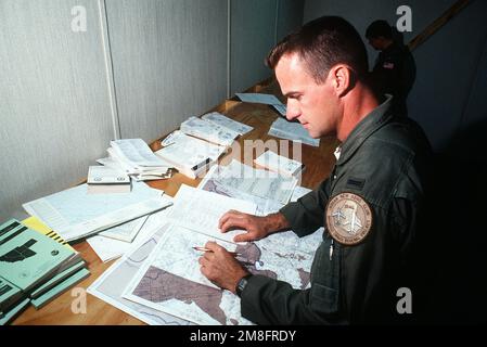 1ST LT. Mike Mathews, Kopilot eines KC-10A-Extender-Flugzeugs, bereitet sich auf eine militärische Luftbordkommando-Luftfrachtmission im Einsatzzentrum der Basis vor. LT. Mathews ist Mitglied des 6. Air Tanken Geschwaders, 22. Air Tanken Flügel, March Air Force Base, Kalifornien. Stützpunkt: Andersen Luftwaffenstützpunkt Bundesstaat: Guam (GU) Land: Vereinigte Staaten von Amerika (USA) Stockfoto