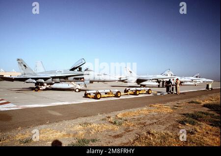 Geschwader versammeln sich auf der Fluglinie, bevor SIE AIM-7-Sparrow-Raketen an Bord von drei Strike Fighter Squadron 303 (VFA-303) F/A-18A Hornet-Flugzeugen laden. Basis: Marineflugstation, Lemoore Bundesstaat: Kalifornien (CA) Land: Vereinigte Staaten von Amerika (USA) Stockfoto