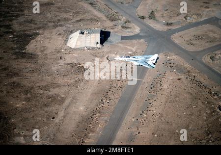 Ein Kampfgeschwader 114 (VF-114) F-14A Tomcat fliegt über einem Teil des Flugplatzes Al Jaber. Der Flugplatz wurde während der Operation Desert Storm schwer beschädigt. Betreff Betrieb/Serie: WÜSTENSTURMLAND: Kuwait (KWT) Stockfoto