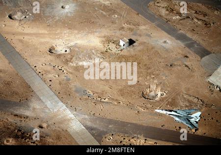 Ein Kampfgeschwader 114 (VF-114) F-14A Tomcat fliegt über einen Teil des A1 Jaber Airfield. Der Flugplatz wurde während der Operation Desert Storm schwer beschädigt. Betreff Betrieb/Serie: WÜSTENSTURMLAND: Kuwait (KWT) Stockfoto