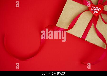Papierkunst Valentinstag-Konzeptbanner mit handgemachter Geschenkbox, Papierband, Schleife und vielen Herzen auf rotem Hintergrund mit Platz für Text Stockfoto