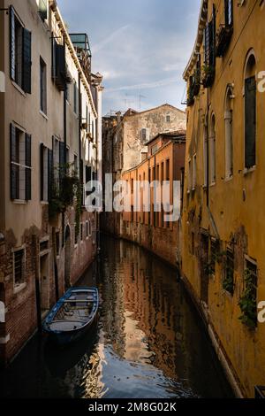 Kleiner Kanal mit verankertem Boot in Venedig, Italien mit romantischen alten Häusern Stockfoto