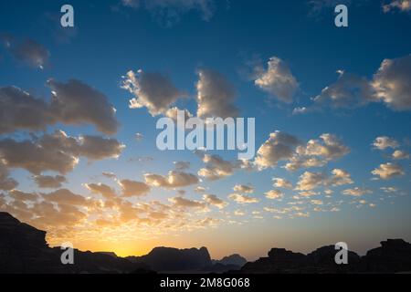 Blauer und gelber Abendhimmel bei Sonnenuntergang mit Wolken in Wadi Rum, Jordanien Stockfoto
