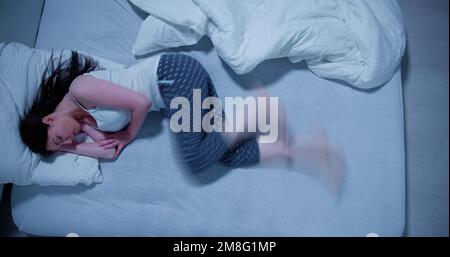 Frau mit RLS - Restless-Legs-Syndrom. Schlafen Im Bett Stockfoto