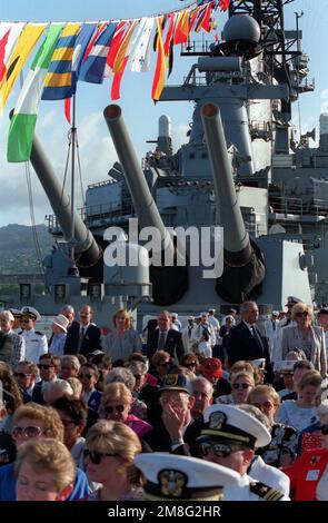 Gäste versammeln sich in der Nähe der Mark 7 16-Zoll 50 Kaliber Gewehre des Schlachtschiff USS MISSOURI (BB-63), während sie sich im Fernsehen Veranstaltungen anlässlich des 50. Jahrestages des japanischen Angriffs auf Pearl Harbor ansehen. Der MISSOURI besucht Pearl Harbor zu Ehren des Ereignisses. Basis: Pearl Harbor Bundesstaat: Hawaii(HI) Land: Vereinigte Staaten von Amerika (USA) Stockfoto