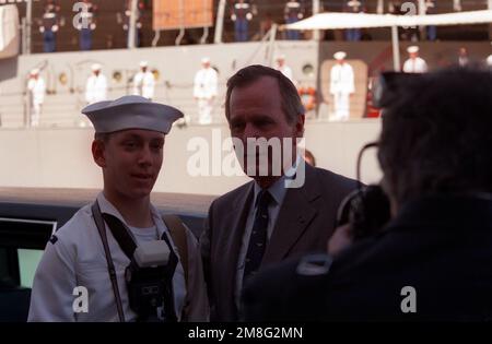 Präsident George Bush posiert für ein Foto mit einem Seemann während einer Gedenkfeier zum 50. Jahrestag des japanischen Angriffs auf Pearl Harbor. Basis: Pearl Harbor Bundesstaat: Hawaii(HI) Land: Vereinigte Staaten von Amerika (USA) Stockfoto
