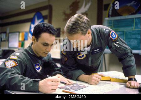 2LT David Wyatt überprüft seinen vorgeschlagenen Low-Level-Flugplan mit dem anderen Studentenpiloten CPT Russ Magargle.die beiden Männer nehmen am Euro-NATO Joint Jet Pilot Training Wing 80. Teil. Basis: Luftwaffenstützpunkt Sheppard Bundesstaat: Texas(TX) Land: Vereinigte Staaten von Amerika(USA) Stockfoto