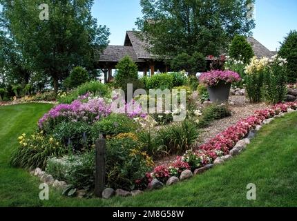 Schöner formeller Garten mit Lilien, Phlox, Begonien, Petunien und anderen Blumen in den Panola Valley Gardens, einem Veranstaltungsort für Hochzeiten in Lindstrom, Minnesota. USA Stockfoto