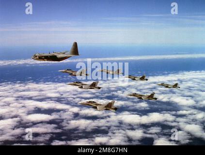 Linke Seitenansicht einer Formation von sieben F/A-18A- und F/A-18D-Hornet-Kampfflugzeugen, die eine Marine Group mit 350 (VMGR-35) KC-130R-Tankflugzeugen des Hercules im Flug über die Marine Corps Air Station verfolgen. Basis: Marine Corps Air Station El Toro Bundesstaat: Kalifornien (CA) Land: Vereinigte Staaten von Amerika (USA) Stockfoto