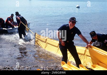 Mitglieder der Küstenwache Marine Safet6y Office, Honolulu, richteten während einer Übung einen Ölunfall-Eindämmungsboom ein. Basis: Exxon Valdez Bundesstaat: Hawaii(HI) Land: Vereinigte Staaten von Amerika (USA) Stockfoto