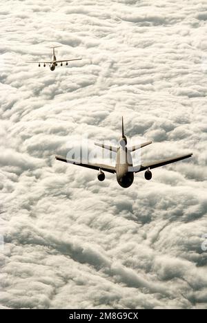 Ein 7. Airlift-Geschwader (7. AS) C-141B Starlifter folgt einem 79. Air Tanken-Geschwader (79. AREFS) KC-10A Extender-Flugzeug in Vorbereitung auf das Tanken. Die Flugzeuge fliegen über Wolkenbänke. Staat: Kalifornien (CA) Land: Vereinigte Staaten von Amerika (USA) Stockfoto