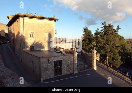 SAN GIMIGNANO, ITALIEN, AM 27. AUGUST 2014. Abendliche Aussicht auf Gebäude und Straße. Eintritt in ein Anwesen. Editorial use. Stockfoto