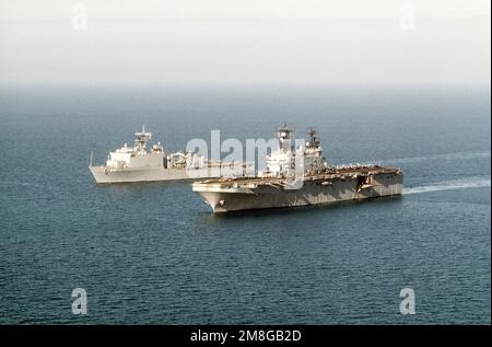 Ein Hafenbogenblick auf das amphibische Sturmschiff USS NASSAU (LHA-4), Vordergrund, und das Dock-Landungsschiff USS GUNSTON HALL (LSD-44), Hintergrund, das während der Operation Desert Shield im Gange ist. Betroffene Operation/Serie: WÜSTENSCHILD Land: Unbekannt Stockfoto