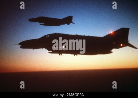 Eine Luft-Luft-Ansicht von links von zwei F-4G Wild Weasel Flugzeugen bei Sonnenuntergang während Operation Desert Shield. Betreff Operation/Serie: WÜSTENSCHILD Land: Saudi-Arabien (Sau) Stockfoto