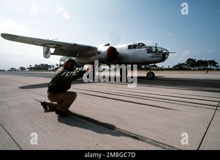 Navy Lieutenant Greg Sullivan, Katapult-Offizier des Flugzeugträgers USS RANGER (CV-61), praktiziert einen „Start“ mit dem Piloten eines restaurierten B-25 Mitchell Bombers. Der Bomber und andere B-25s sind auf North Island, um für eine Nachstellung des 18. April 1942, Razzia von B-25s, den „Doolittle Raiders“, zu üben, die vom Flugzeugträger USS HORNET (CV-8) beim ersten US-Angriff auf Japans Heimatland während des Zweiten Weltkriegs gestartet wurde Die Nachstellung findet am 21. April 1992 vom RANGER bei San Diego statt. Basis: Marineflugstation, Nordinsel Bundesstaat: Kalifornien(CA) Land: Vereinigte Staaten von Amerika (USA) Stockfoto