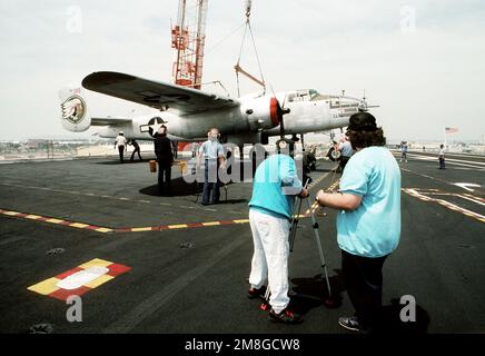 Ein Kran stellt ein restauriertes B-25 Mitchell Bomberflugzeug auf das Deck des Flugzeugträgers USS RANGER (CV-61). Es und eine weitere B-25 werden in einer Nachstellung von „Doolittle's RAID“ vom 18. April 1942 gestartet, in der 16 B-25s vom Flugzeugträger USS HORNET (CV-8) beim ersten Angriff auf Japan auf das Festland gestartet wurden. Basis: Marineflugstation, Nordinsel Bundesstaat: Kalifornien(CA) Land: Vereinigte Staaten von Amerika (USA) Stockfoto