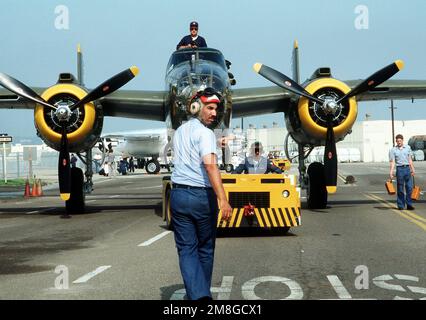 Ein restauriertes B-25 Mitchell-Bomberflugzeug wird zu einem Pier geschleppt, wo es mit einem Kran an an Bord des Flugzeugträgers USS RANGER (CV-61) angehoben wird. Es und eine weitere B-25 werden in einer Nachstellung von „Doolittle's RAID“ vom 18. April 1942 gestartet, in der 16 B-25s vom Flugzeugträger USS HORNET (CV-8) beim ersten Angriff auf Japan auf das Festland gestartet wurden. Basis: Marineflugstation, Nordinsel Bundesstaat: Kalifornien(CA) Land: Vereinigte Staaten von Amerika (USA) Stockfoto