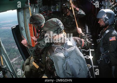 TECH. SGT. Michael Schoenberger, Lastenführer der Airlift Group 179., Ohio Air National Guard, unterstützt einen Sprungmeister des XVIII Airborne Corps der Armee, während sich die Truppen auf den Fallschirm aus einem C-130 Hercules-Flugzeug während einer Trainingsübung vorbereiten. Basis: Luftwaffenstützpunkt Pope Bundesstaat: North Carolina (NC) Land: Vereinigte Staaten von Amerika (USA) Stockfoto