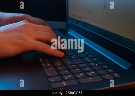 Hände eines Mannes, der auf einer Laptop-Tastatur tippt. Ein Mann, der an einem Laptop arbeitet. Selektiver Fokus Stockfoto