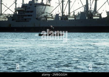 Mitglieder eines US-amerikanischen Die Küstenwache patrouilliert das Wasser während der Operation Desert Shield in einem Sicherheitsboot des Jägerhafens. Das Schiff passiert den vom Sealift-Kommando GECHARTERTEN FRACHTHAFEN JUBY (T-AK-5077). Betreff Operation/Serie: WÜSTENSCHILD Land: Saudi-Arabien (Sau) Stockfoto