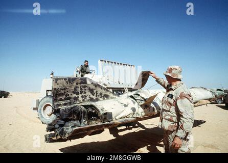 SENIOR MASTER SGT. James Miles von der 4409. Sprengstoff-Entsorgungsstelle, Myrtle Beach, S.C., untersucht die Überreste einer Scud-Rakete, die während der Operation Desert Storm von einer MIM-104 Patriot-Luftrettungsrakete außerhalb von Riad abgeschossen wurde. PERSONAL SGT. Stephen Olava vom 347. Transportwaffenstützpunkt Moody Air Force Base, Georgia, betreibt einen M-13K Gabelstapler für unebenes Gelände, um die Rakete auf einen Tieflader zu transportieren. Betreff Operation/Serie: WÜSTENSTURM Land: Saudi-Arabien (Sau) Stockfoto