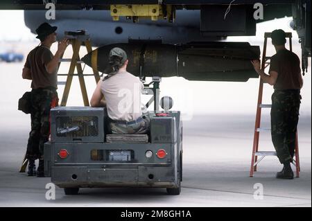 Mitglieder des Munitions Maintenance Squadron von 1708. verwenden einen MJ-1 Bombenlader, um M-117 750-Pfund Bomben auf ein B-52G Stratofortress Bomberflugzeug während der Operation Desert Storm zu laden. Betreff Operation/Serie: WÜSTENSTURM Land: Saudi-Arabien (Sau) Stockfoto