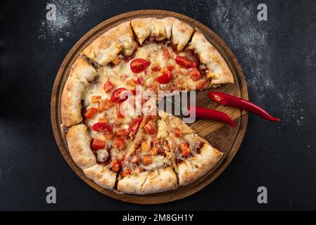 Indische Pizza mit Tomaten und Paprika aus nächster Nähe. Traditionelle indische Pizza auf Brot-Fladenbrot Stockfoto