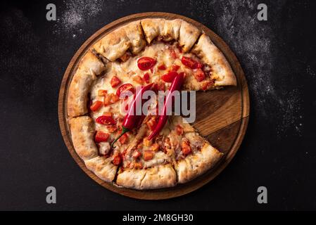 Indische Pizza mit Tomaten und Paprika aus nächster Nähe. Traditionelle indische Pizza auf Brot-Fladenbrot Stockfoto